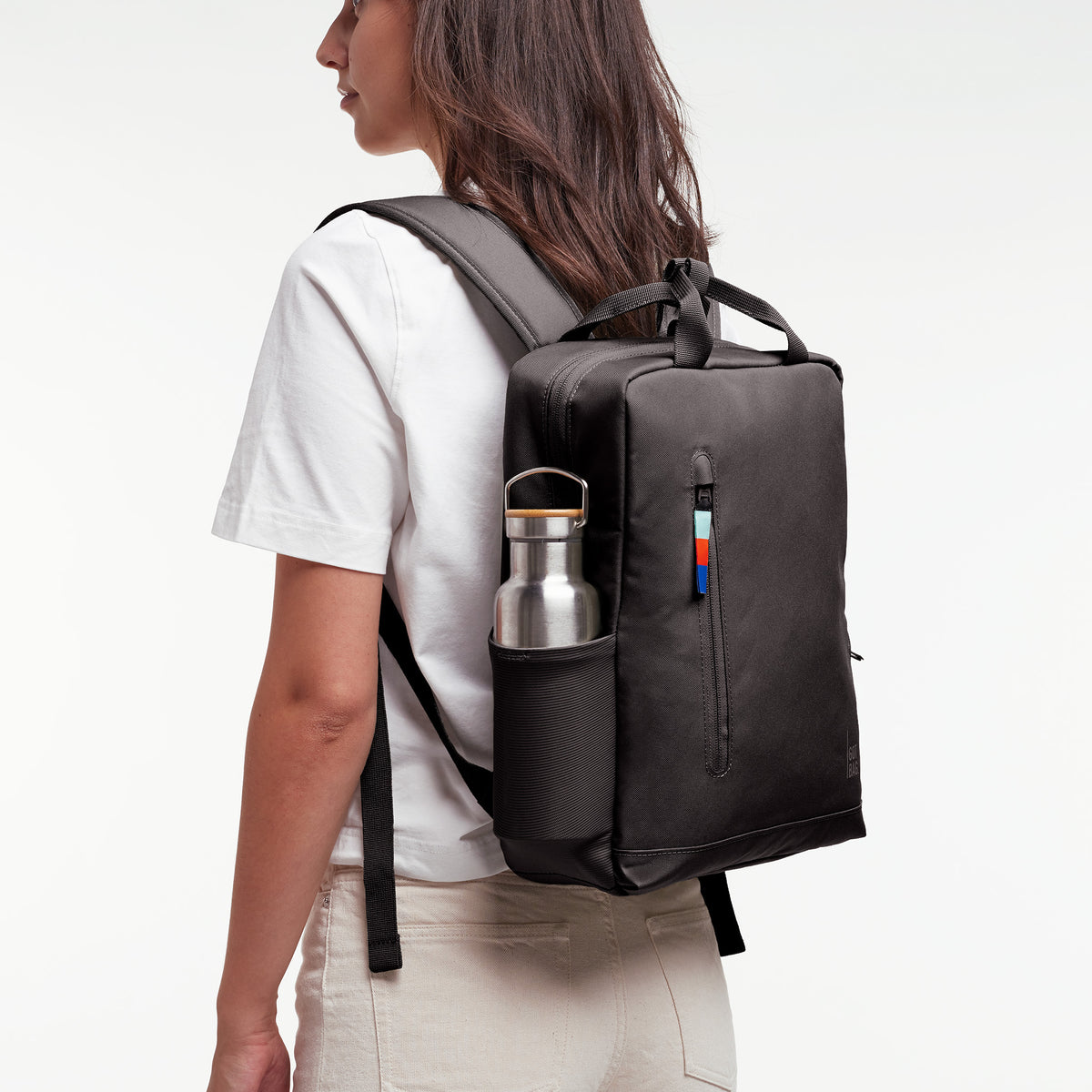 DAYPACK Rucksack in mussel (dunkles Braun-Grau) von einer Frau als Rucksack auf dem Rücken getragen.