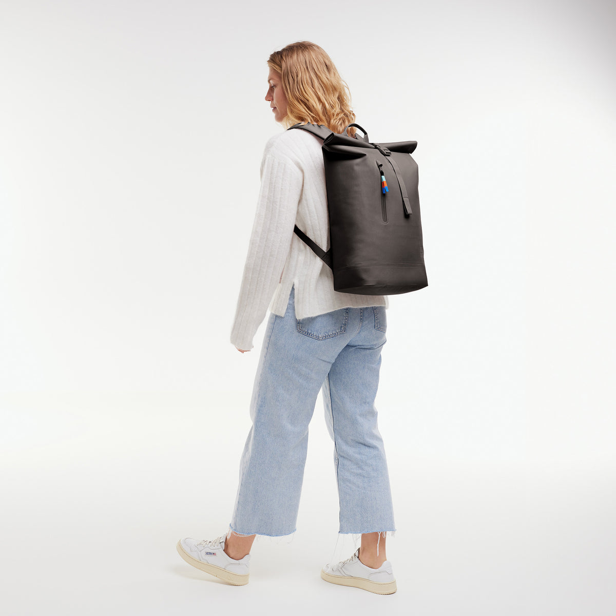 ROLLTOP LITE Rucksack in mussel (dunkles Braun-Grau) von einer Frau auf dem Rücken getragen.