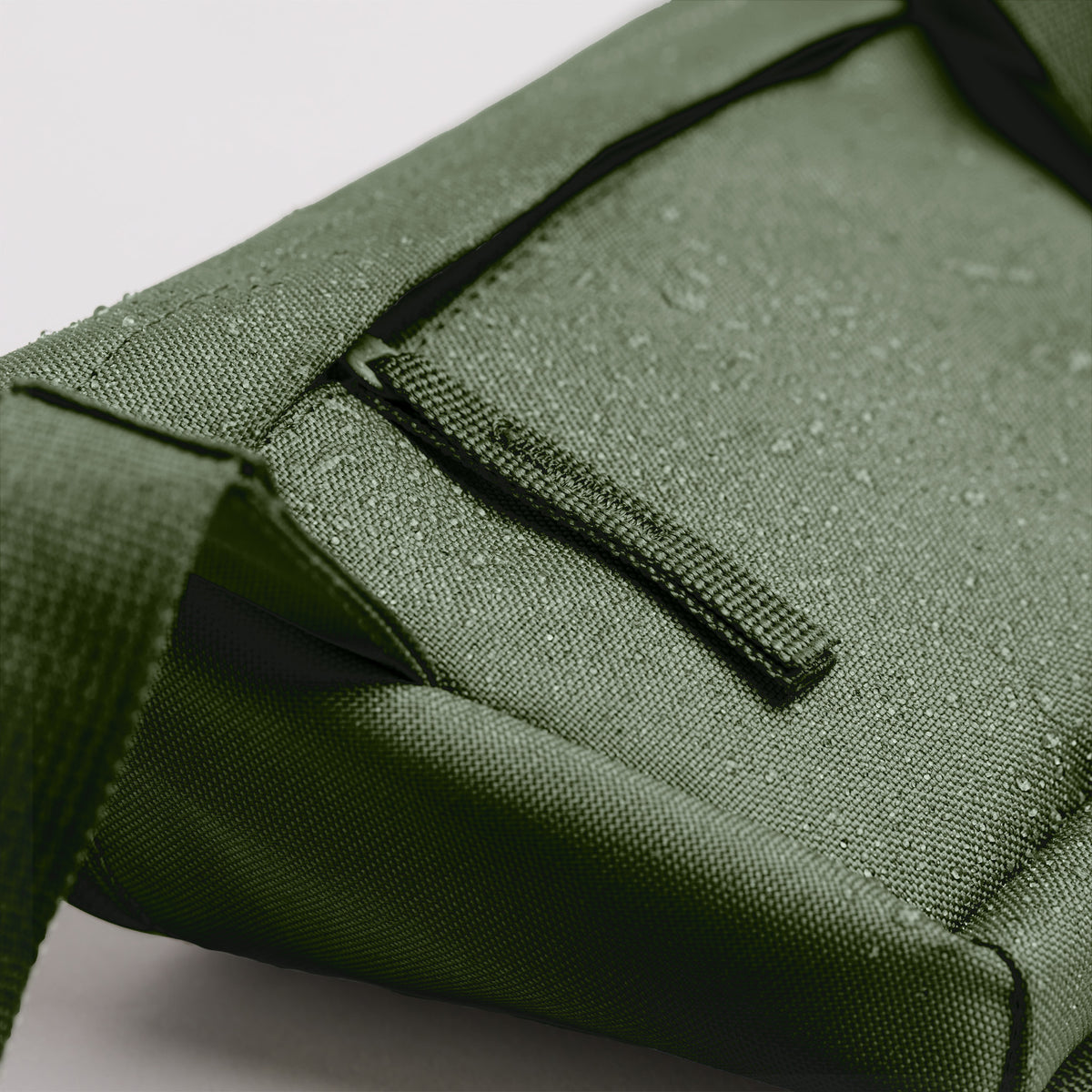 HIP BAG Tasche in seafloor (tiefes Dunkelgrün) als Detailaufnahme mit Wassertropfen auf der Oberfläche.
