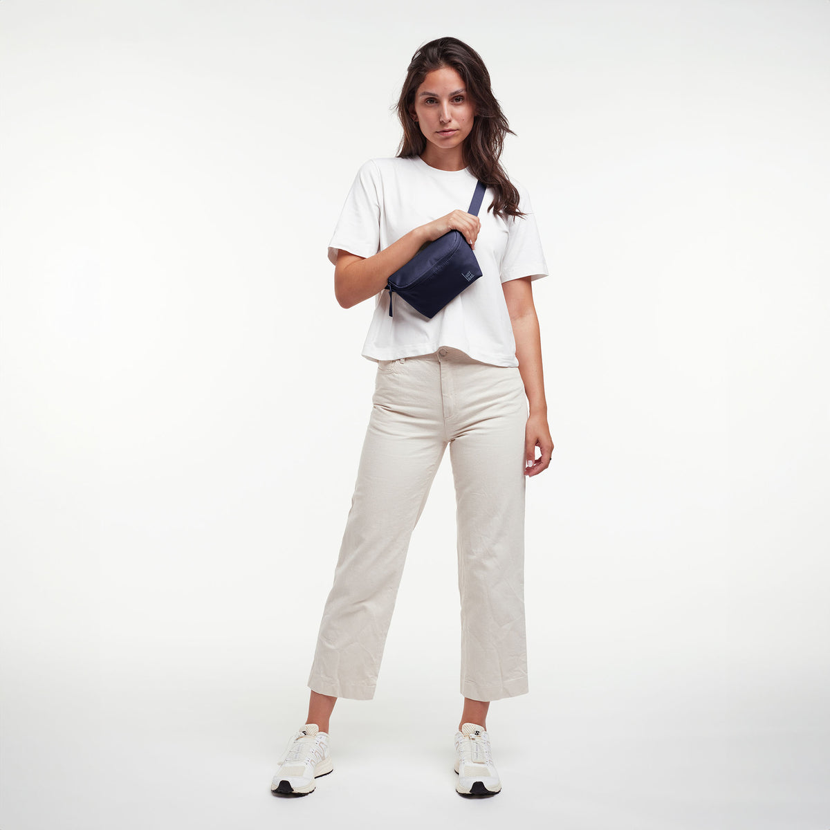 HIP BAG Tasche in tide (tiefes Dunkelblau mit Lilastich) von einer Frau crossbody getragen.
