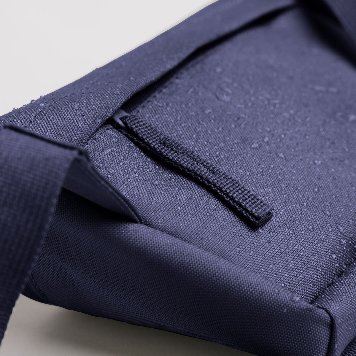 HIP BAG Tasche in tide (tiefes Dunkelblau mit Lilastich) mit Wassertropfen als Detailaufnahme.