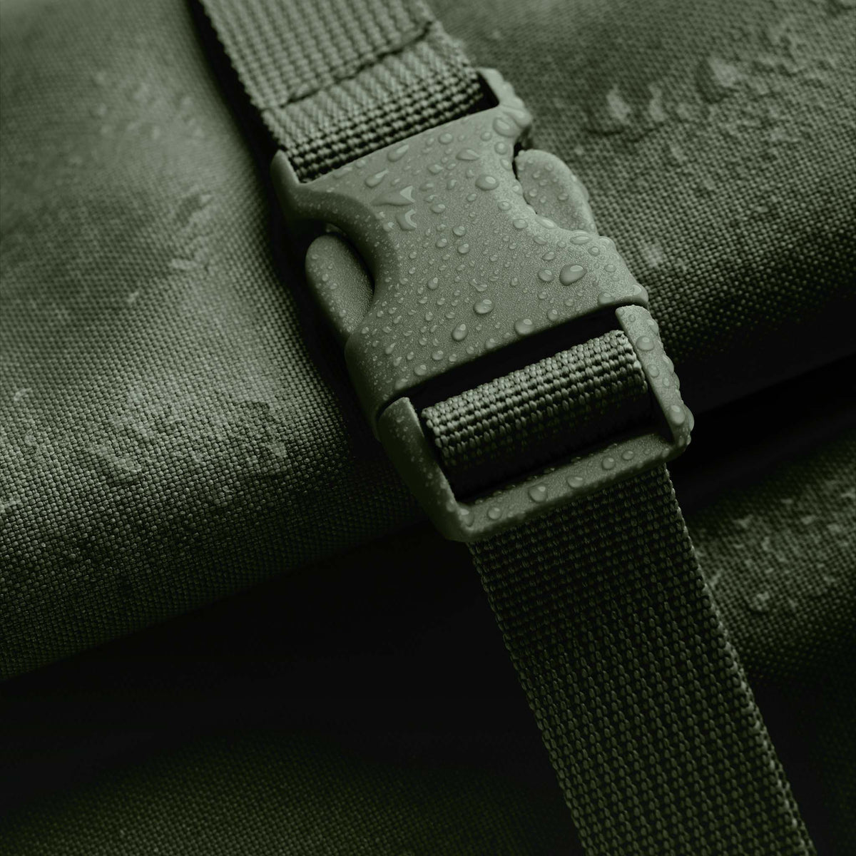 ROLLTOP Rucksack in seafloor (tiefes Dunkelgrün) mit Wassertropfen auf dem Verschluss in Detailaufnahme.
