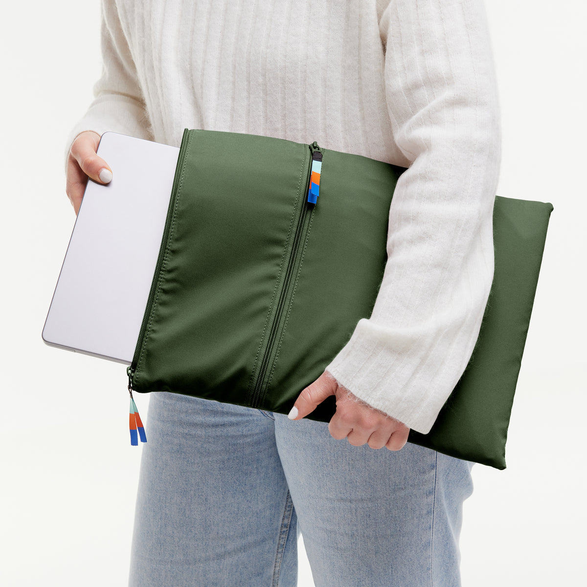ROLLTOP LITE 2.0 Tasche in seafloor (tiefes Dunkelgrün), von einer Frau gehalten, die einen Laptop einsteckt.