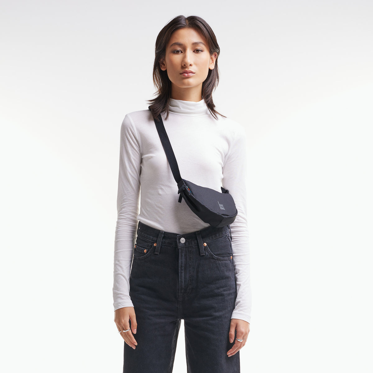 MOON BAG MINI Tasche in black (Schwarz) von einer Frau crossbody getragen.