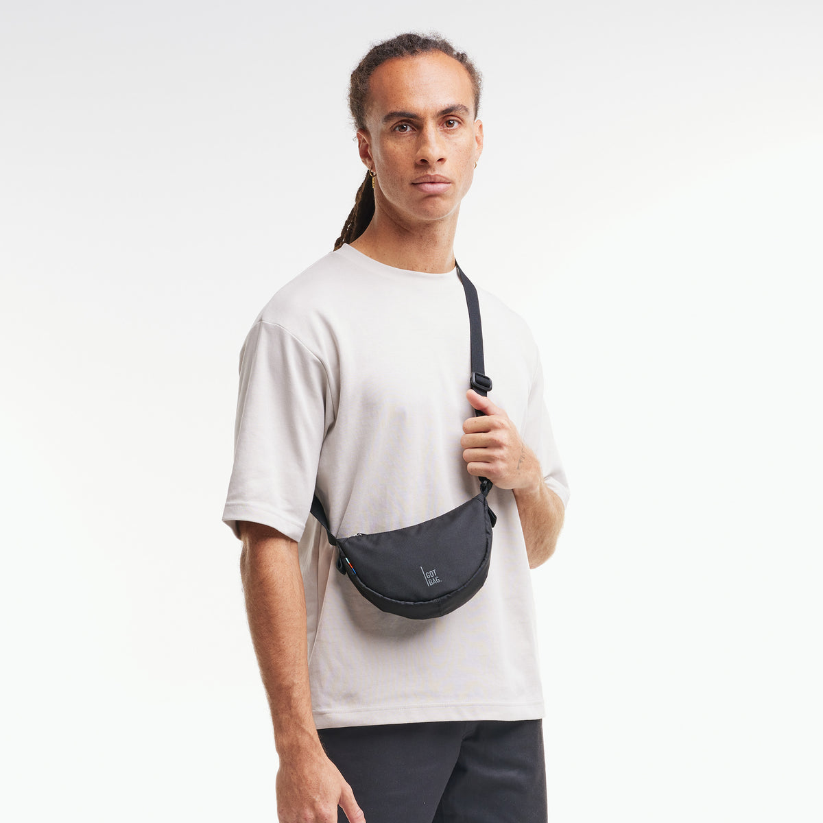 MOON BAG MINI Tasche in black (Schwarz) von einem Mann crossbody getragen.