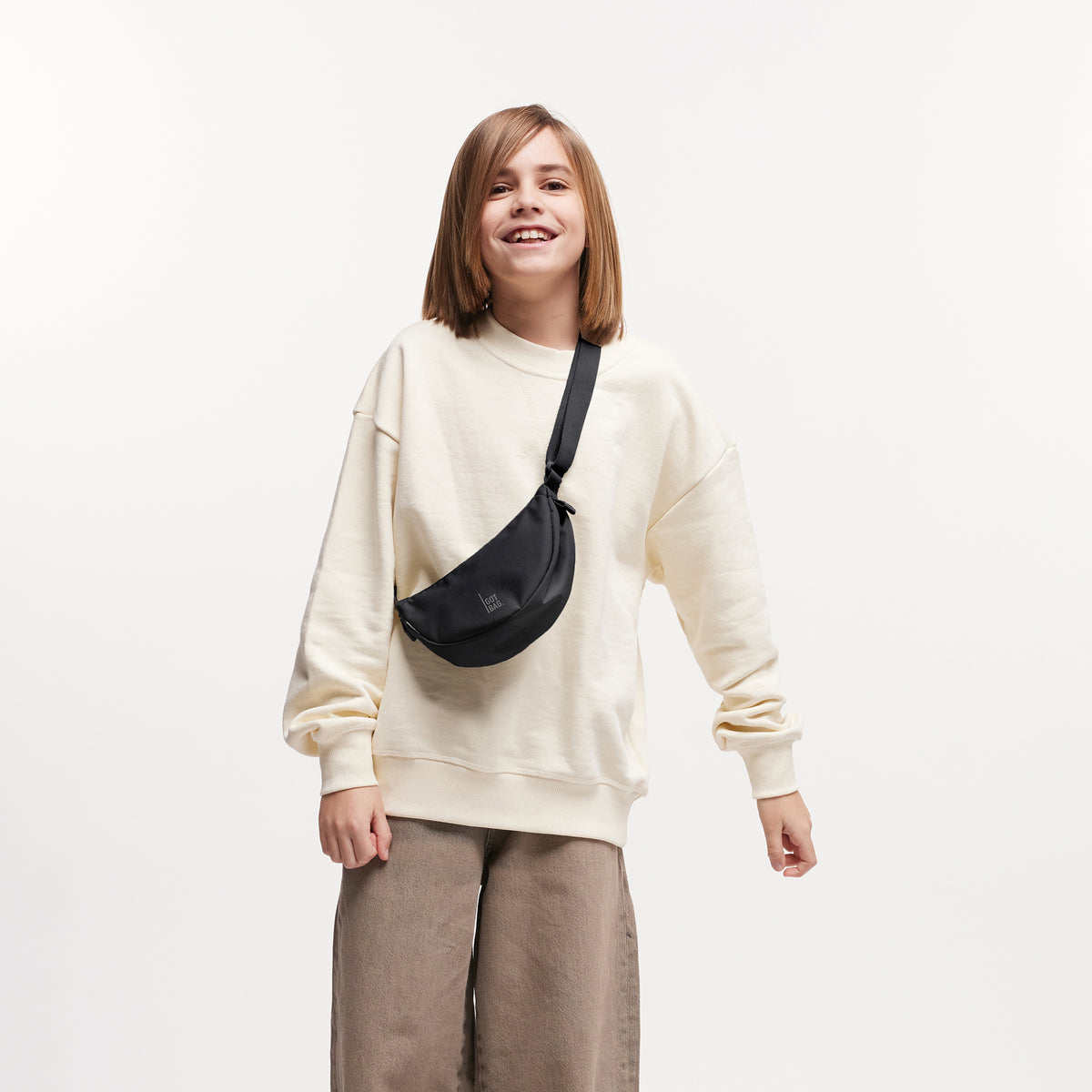 MOON BAG MINI Tasche in black (Schwarz) von einer Frau crossbody getragen.