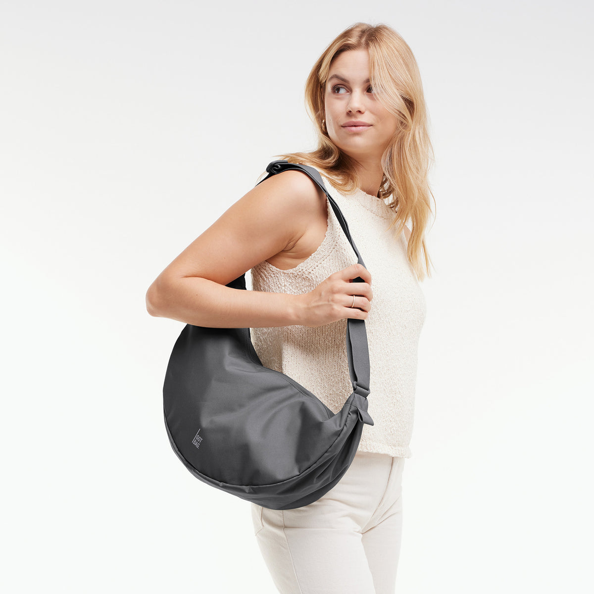 MOON BAG LARGE Tasche in shark (Dunkelgrau) von einer Frau über der Schulter getragen.