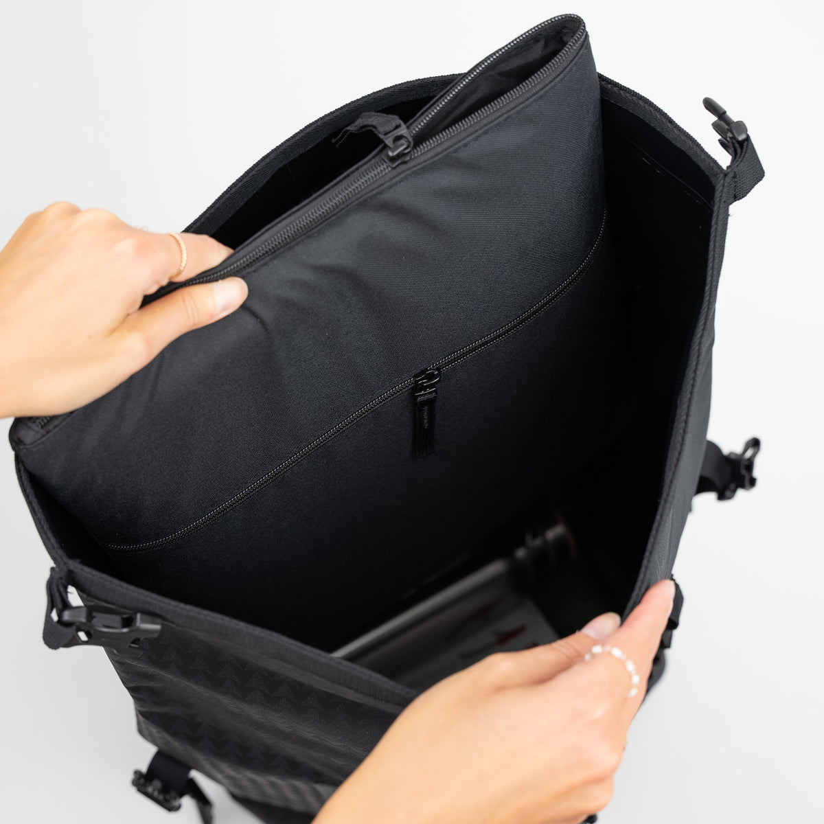 ROLLTOP ON THE ROAM Rucksack in black (Schwarz) von einer Frau geöffnet.