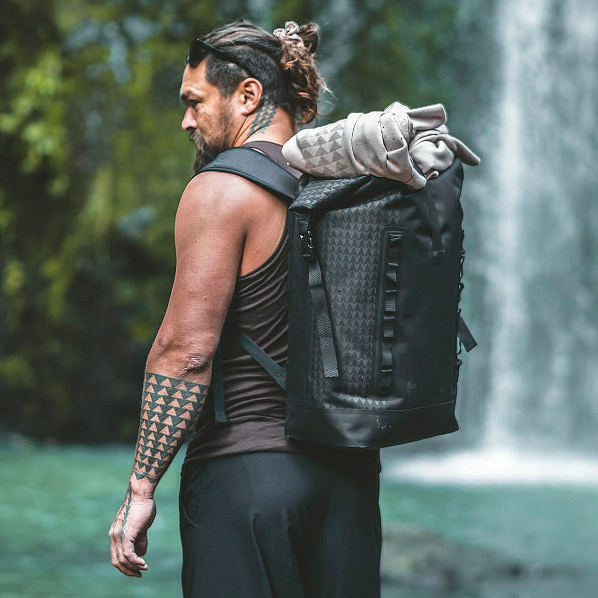 ROLLTOP ON THE ROAM Rucksack in black (Schwarz) von einem Mann auf dem Rücken getragen.