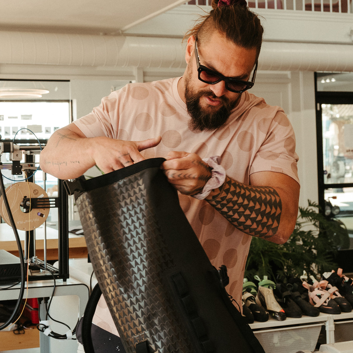 ROLLTOP ON THE ROAM Rucksack in black (Schwarz) von einem Mann gehalten.