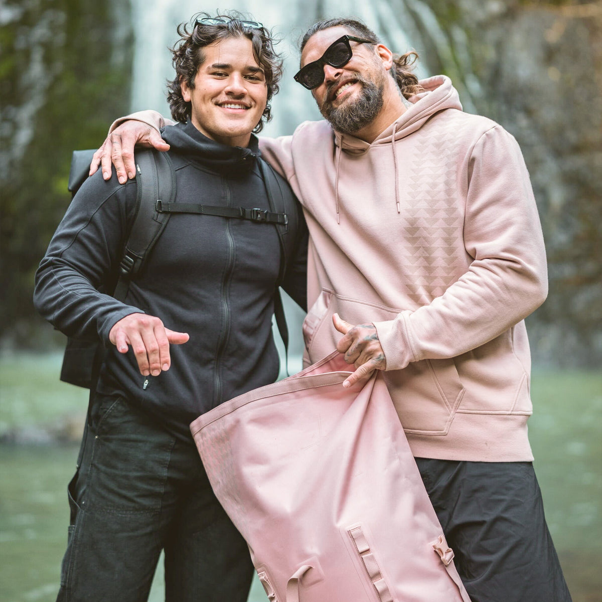 ROLLTOP ON THE ROAM Tasche in dirty pink, von einem Mann in der Hand gehalten, neben einem zweiten Mann.