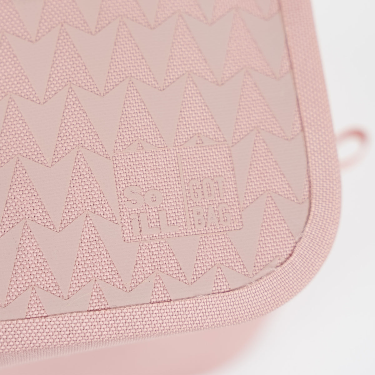 TRAVEL KIT ON THE ROAM Accessoire in dirty pink mit dreieckigem Muster und SO ILL BAG Logo.
