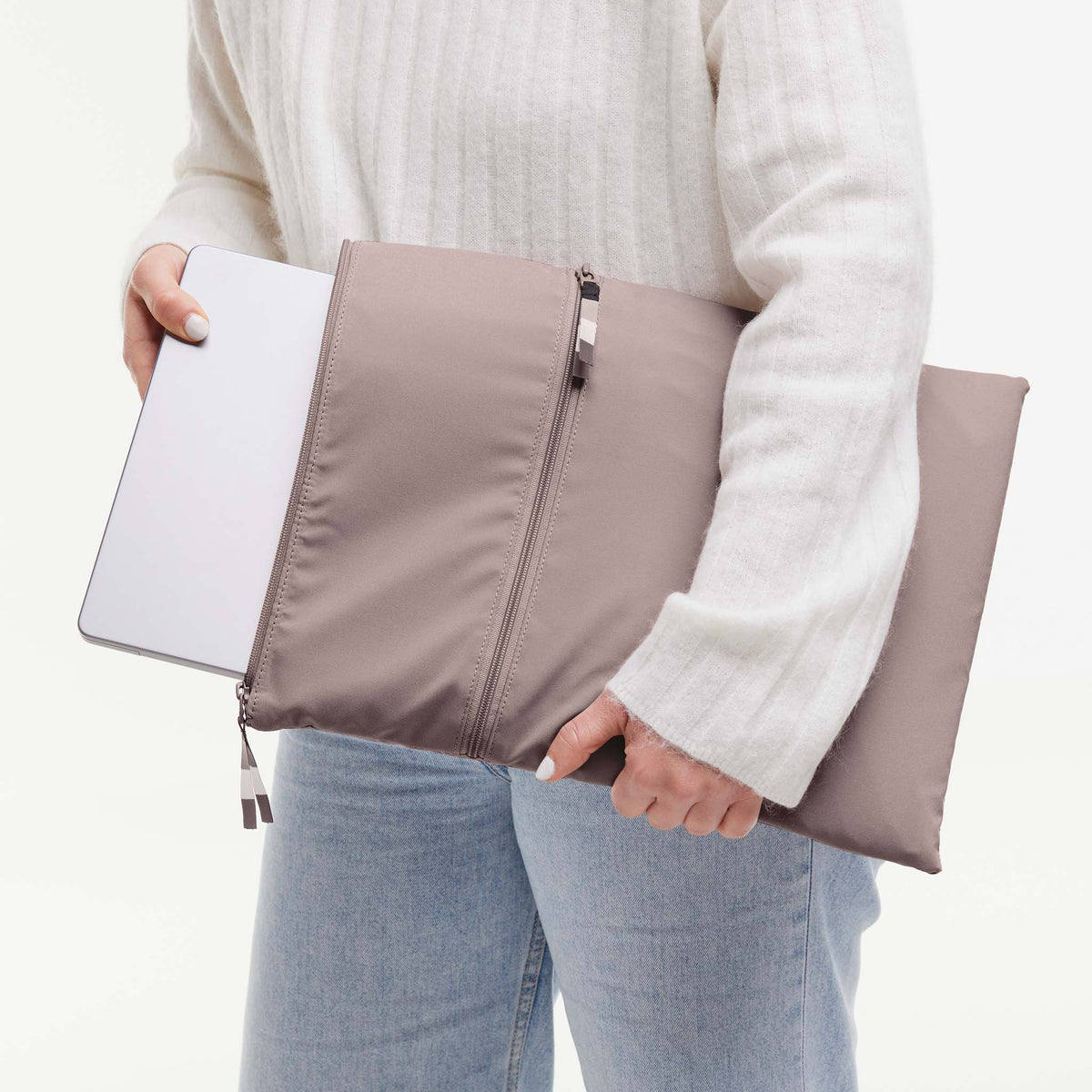 Eine Frau steckt ein Tablet in ein ROLLTOP 2.0 Accessoire in blobfish (dunkles Altrosa).