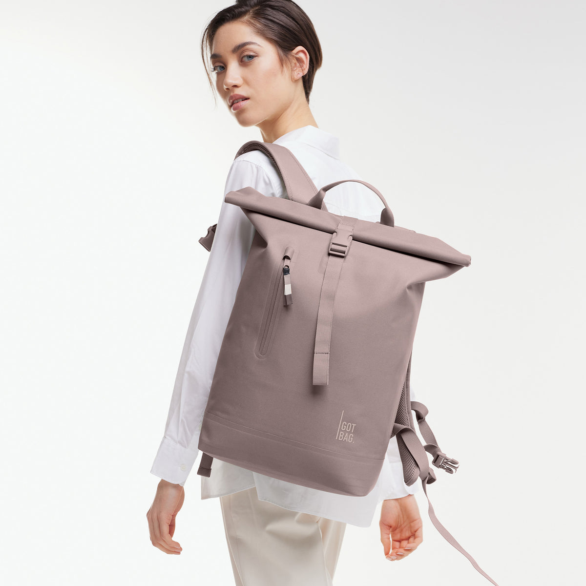 ROLLTOP LITE 2.0 Rucksack in blobfish (dunkles Altrosa) von einer Frau als Rucksack auf dem Rücken getragen.