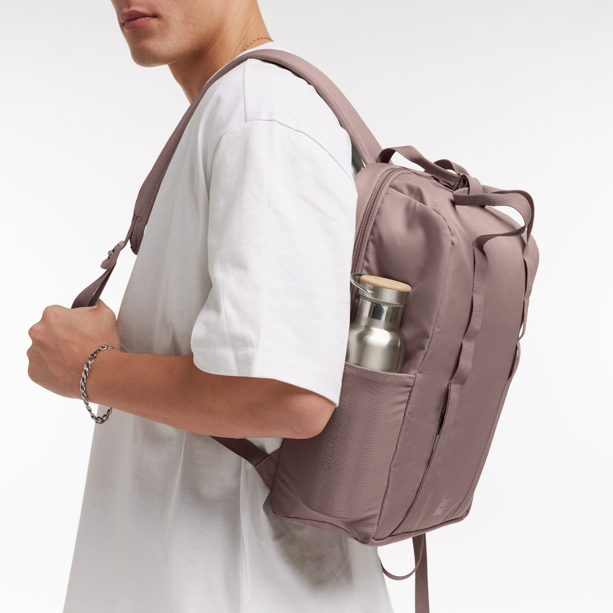 DAYPACK LOOP Rucksack von einem Mann auf dem Rücken getragen, mit einer Trinkflasche in der Seitentasche.
