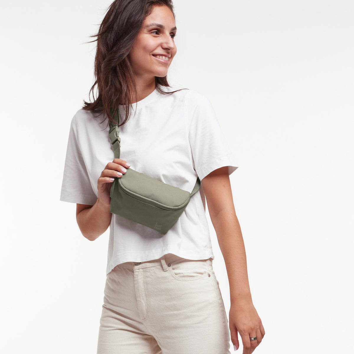 HIP BAG Tasche in seabed (helles Olivgrün) von einer Frau crossbody getragen.