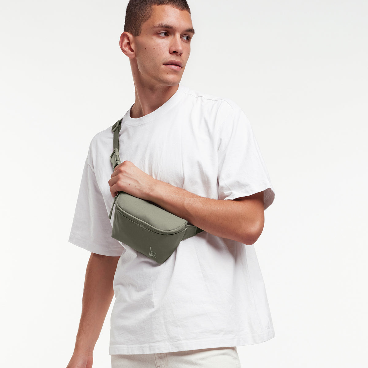 HIP BAG Tasche in seabed (helles Olivgrün) von einem Mann crossbody getragen.