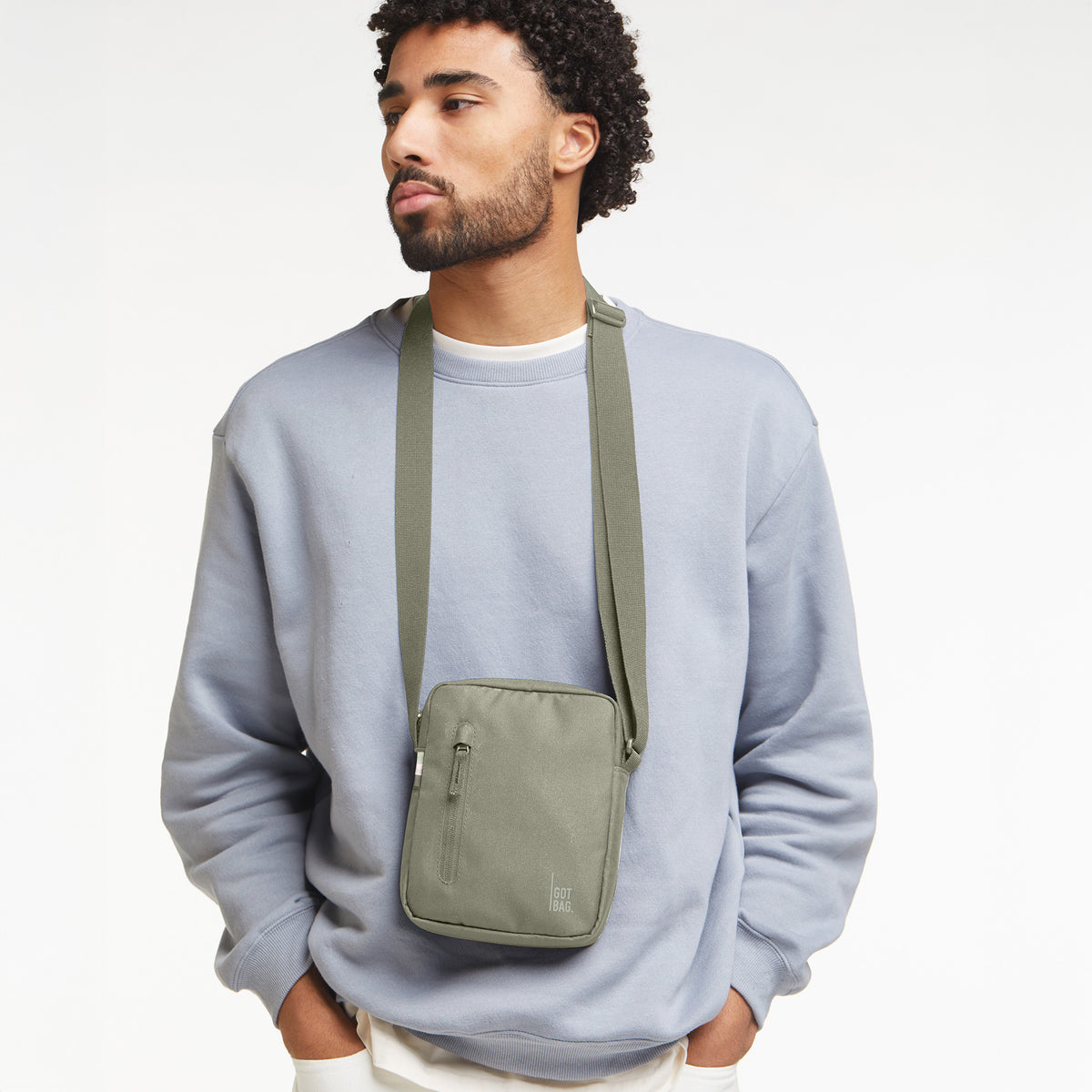 PUSHER BAG Tasche in seabed (helles Olivgrün) von einem Mann crossbody getragen.