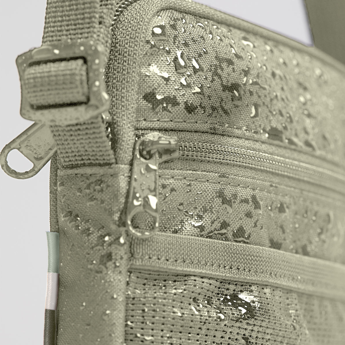 PUSHER BAG Tasche in seabed (helles Olivgrün) mit Wassertropfen, als Detailaufnahme der Oberfläche.