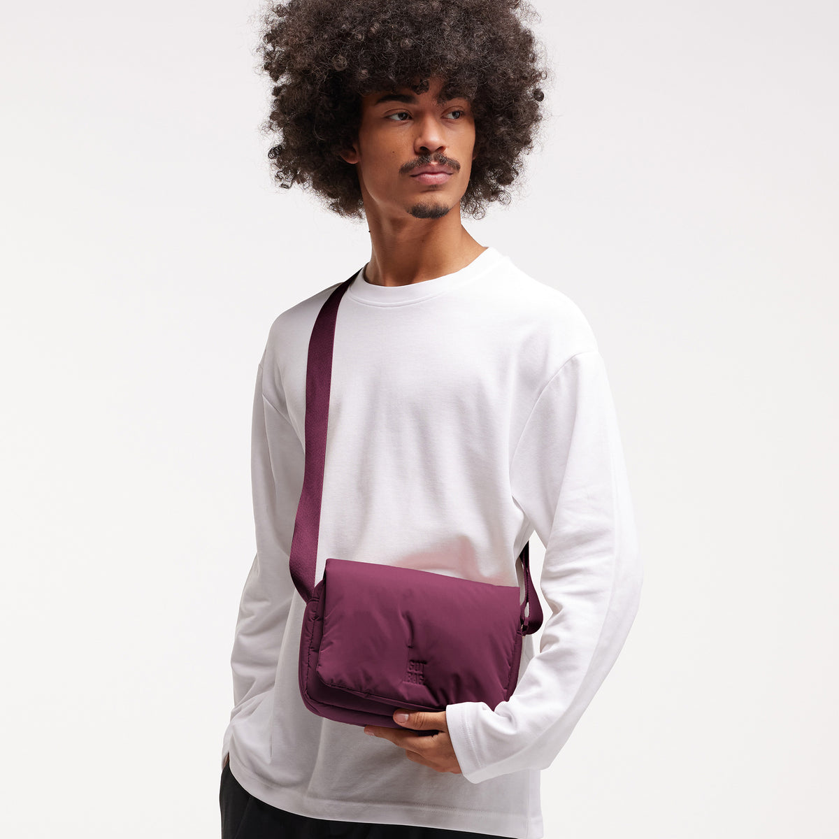 CLOUD CROSSBODY BAG Tasche in kraken (Weinrot) von einem Mann crossbody getragen.
