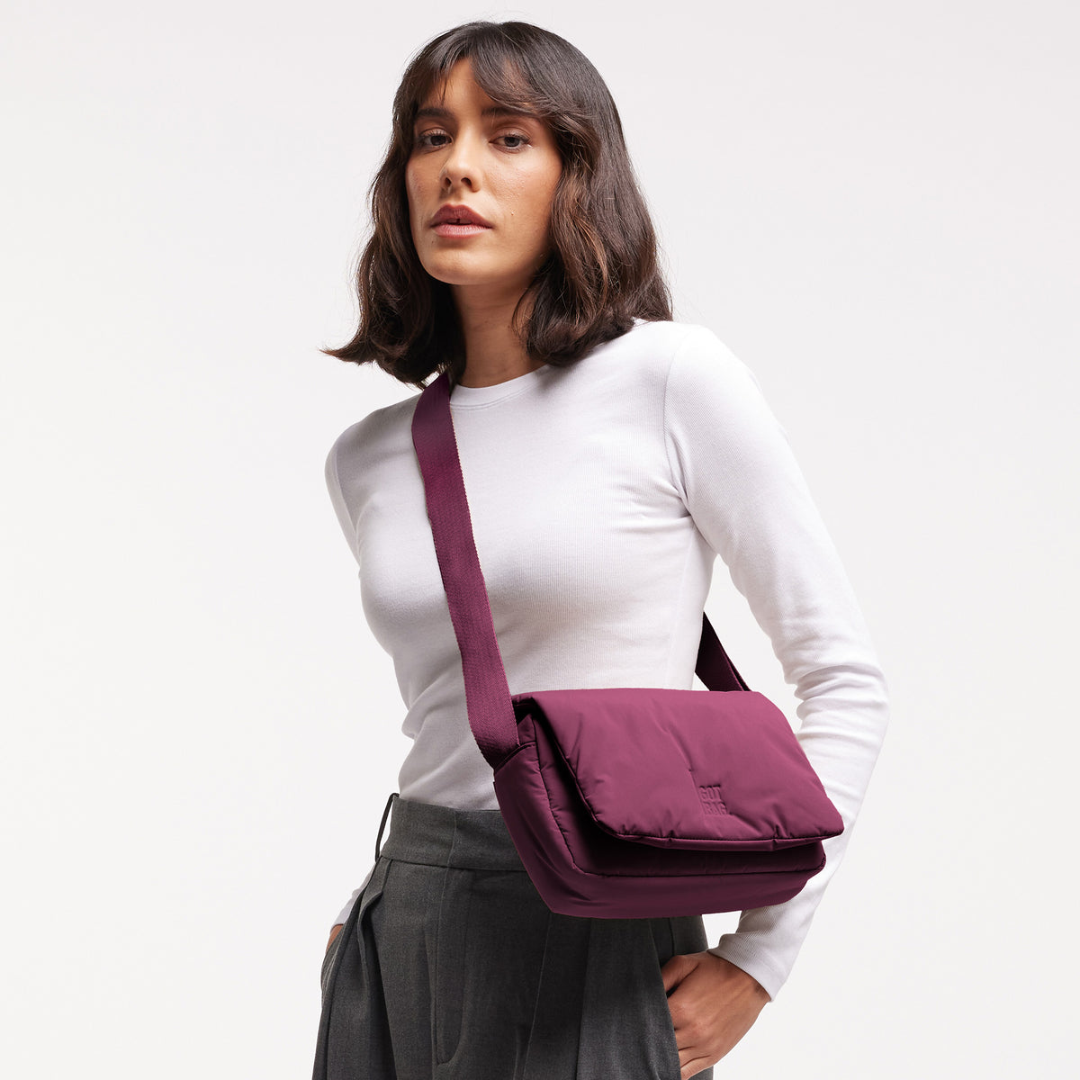 CLOUD CROSSBODY BAG Tasche in kraken (Weinrot) von einer Frau crossbody getragen.