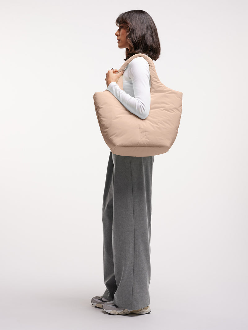 CLOUD TOTE BAG Tasche in sea lemon (zartes Pastellgelb) von einer Frau über der Schulter getragen.