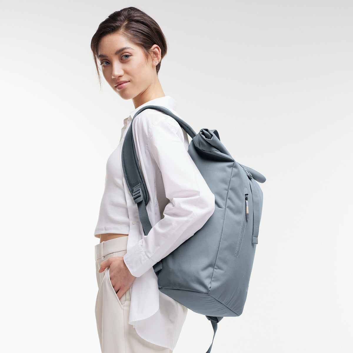 ROLLTOP EASY Rucksack in marlin (grau-blau) von einer Frau als Rucksack auf dem Rücken getragen.