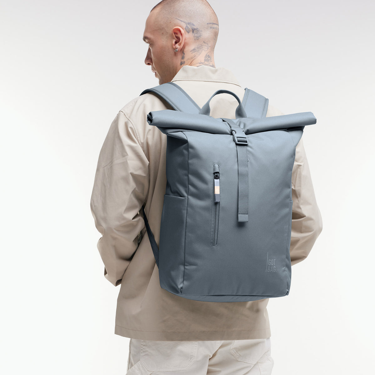ROLLTOP EASY Rucksack in marlin (grau-blau) von einem Mann auf dem Rücken getragen.