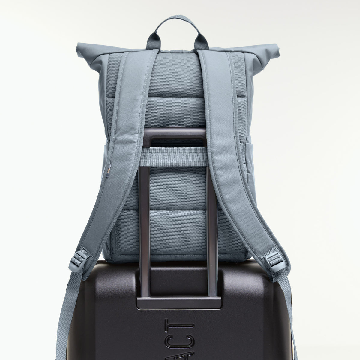 ROLLTOP EASY Rucksack in marlin (grau-blau) auf einem Koffergriff befestigt, von hinten gezeigt.