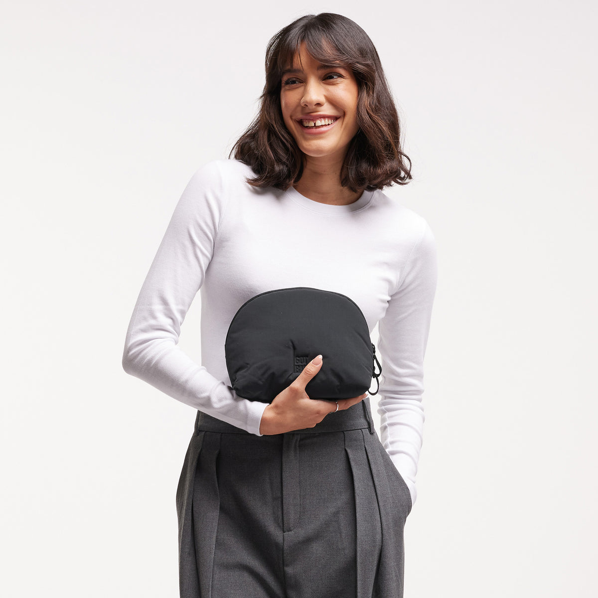 CLOUD POCKET BAG Tasche in black (Schwarz) von einer Frau in der Hand gehalten.