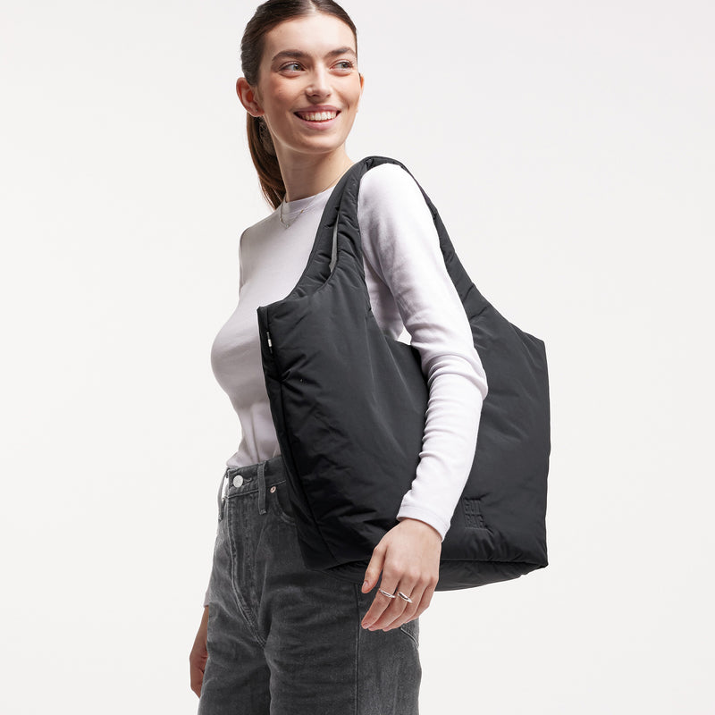 CLOUD TOTE BAG Tasche von einer Frau über der Schulter getragen.