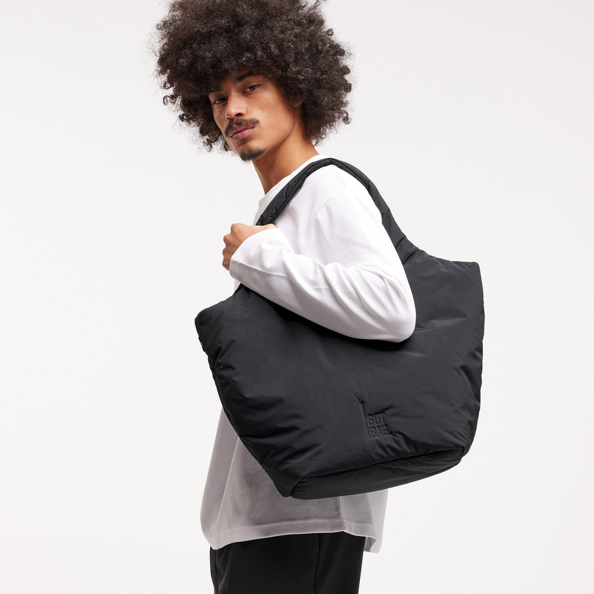 CLOUD TOTE BAG Tasche von einem Mann über der Schulter getragen.