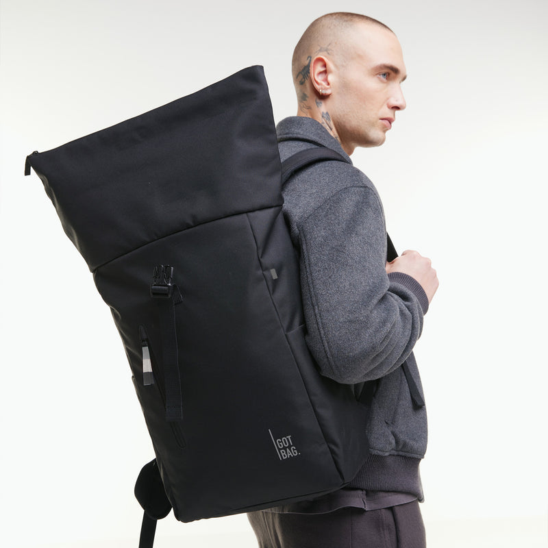 ROLLTOP EASY Rucksack in black (Schwarz) von einem Mann als Rucksack auf dem Rücken getragen.