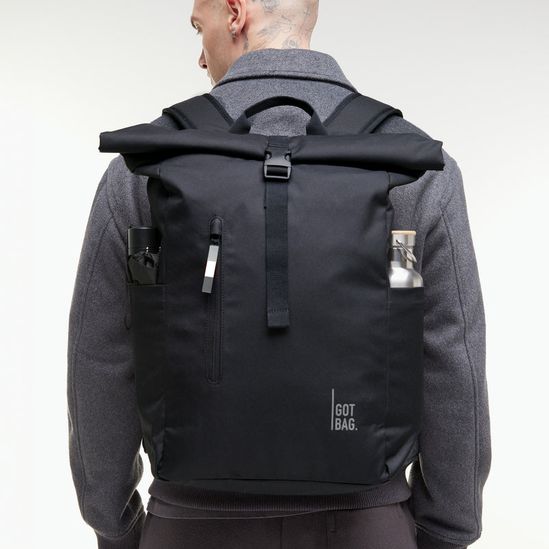 ROLLTOP EASY Monochrome Edition Rucksack in black (Schwarz) von einem Mann auf dem Rücken getragen.