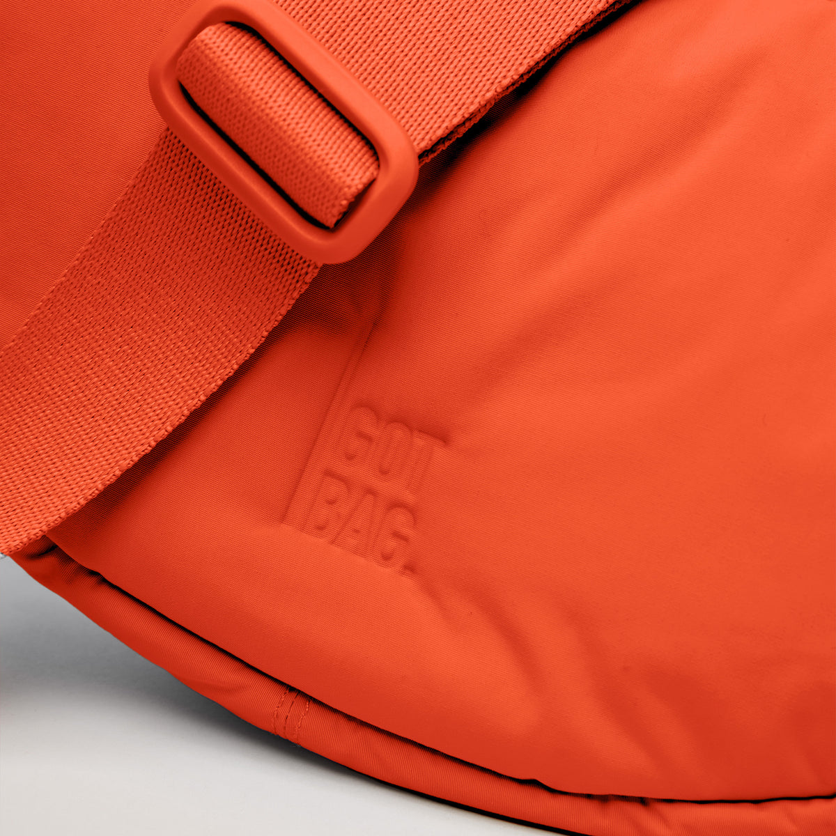 CLOUD MOON BAG SMALL Tasche in hot coral (knalliges Orange) mit geprägtem GOT BAG Logo, Detailaufnahme.