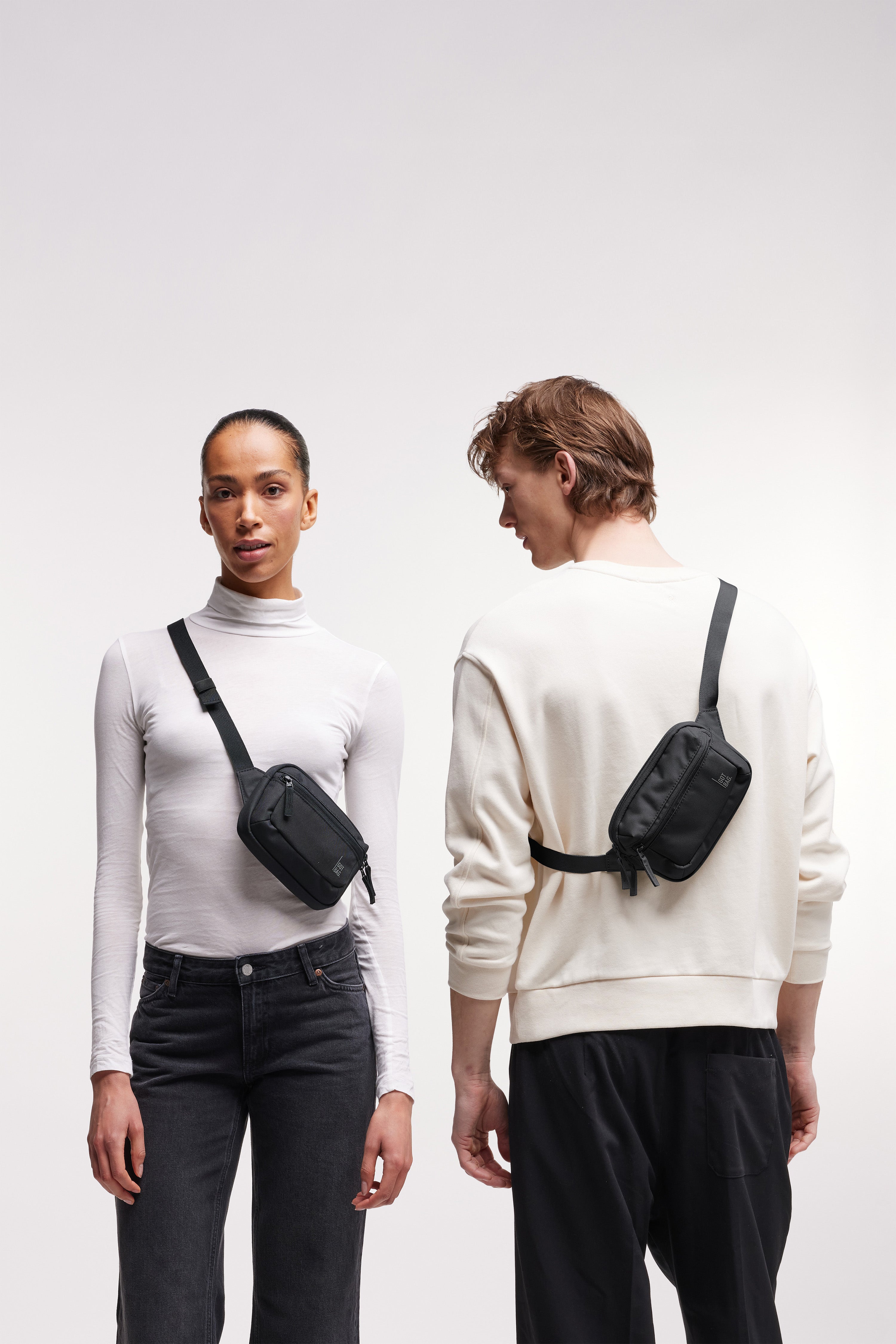 SLING BAG SMALL Tasche in black (Schwarz) von Frau und Mann crossbody getragen.