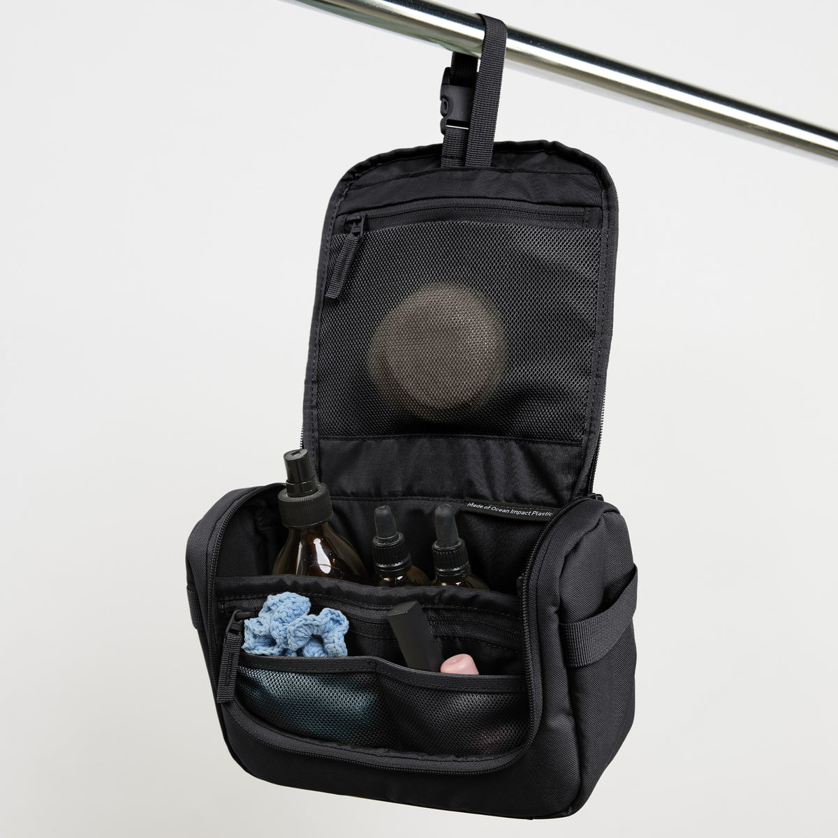 SHOWER KIT Accessoires in black (Schwarz) geöffnet, an einer Stange hängend und Inhalt zeigend.