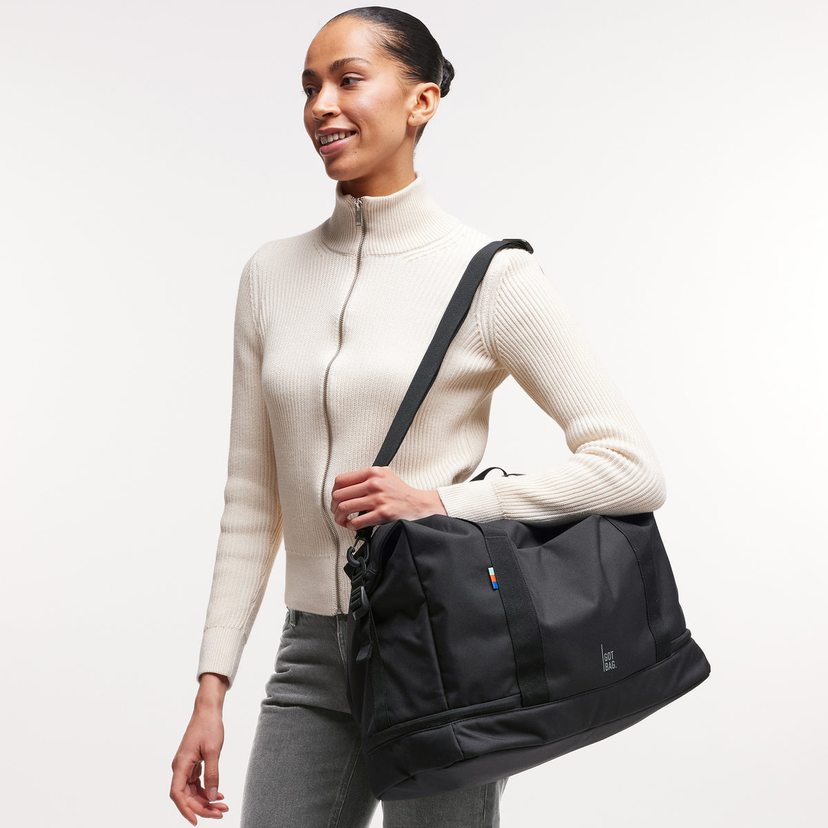 WEEKEND BAG Tasche in black (Schwarz) von einer Frau über der Schulter getragen.