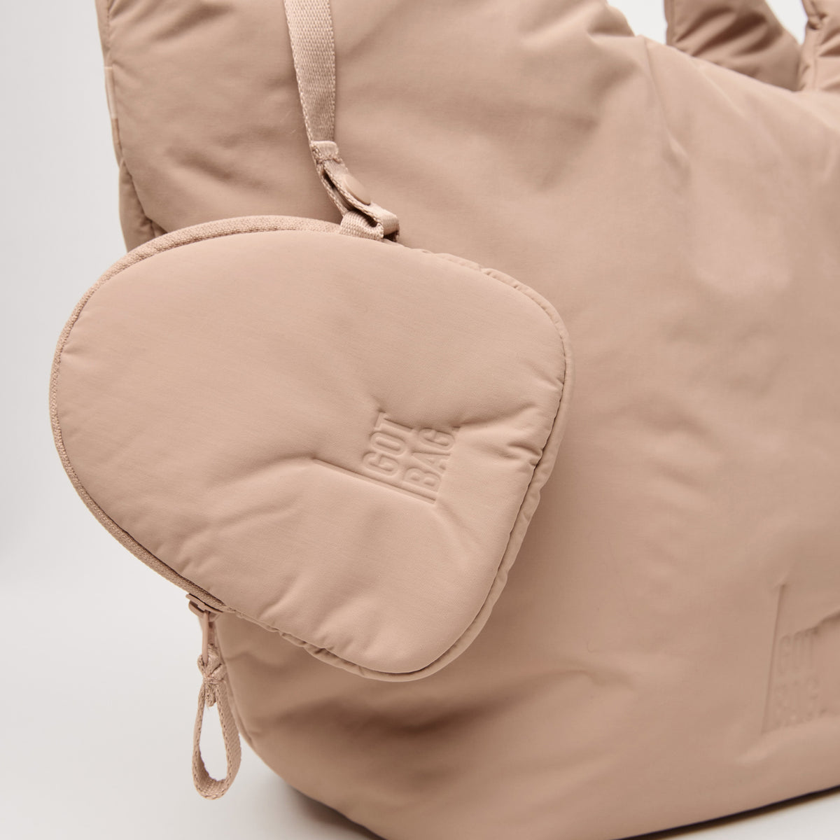 CLOUD TOTE BAG Tasche in sandbar (warmes Beige mit rötlichem Unterton) mit angehängtem Beutel, Nahaufnahme.