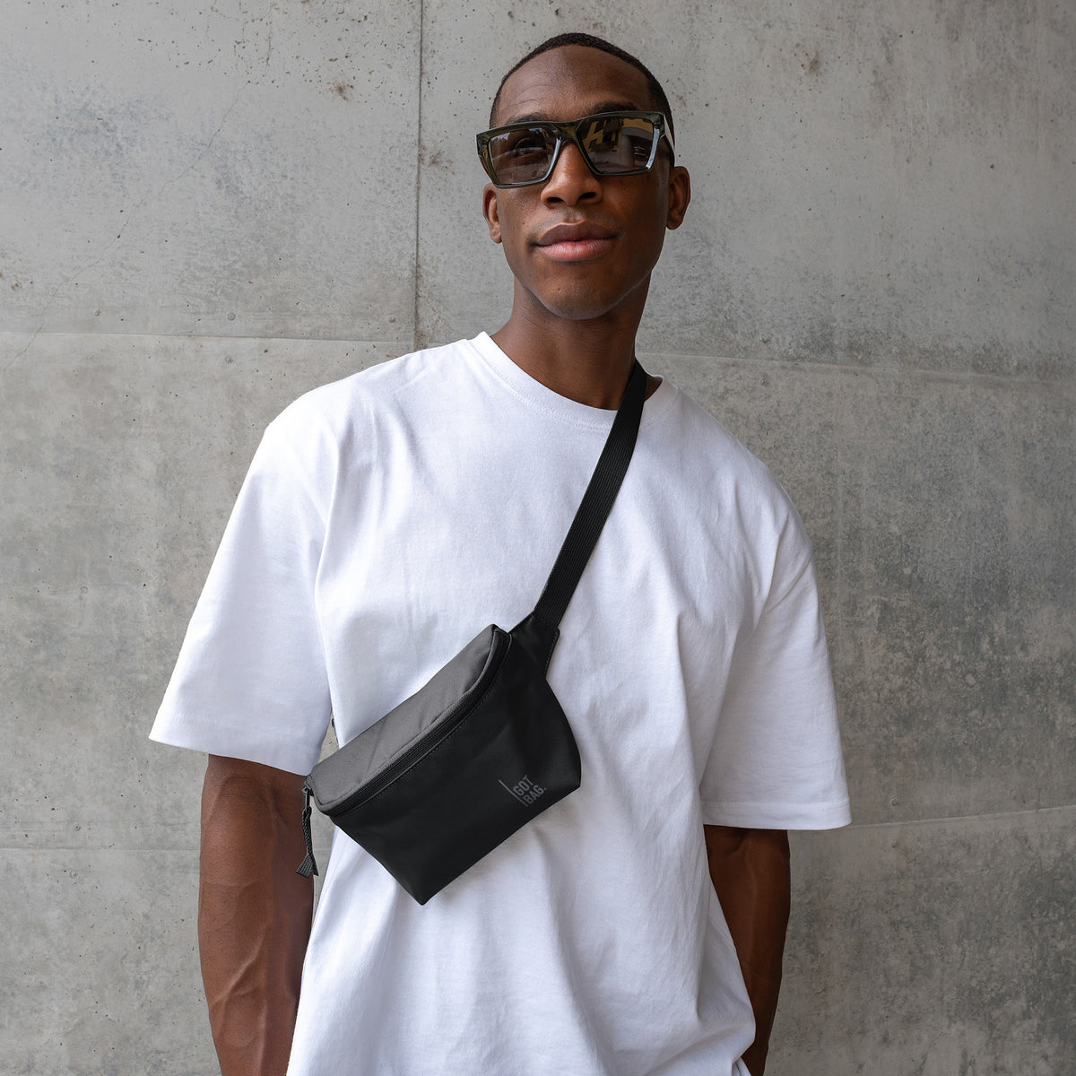 HIP BAG Tasche in black (Schwarz) von einem Mann crossbody getragen.