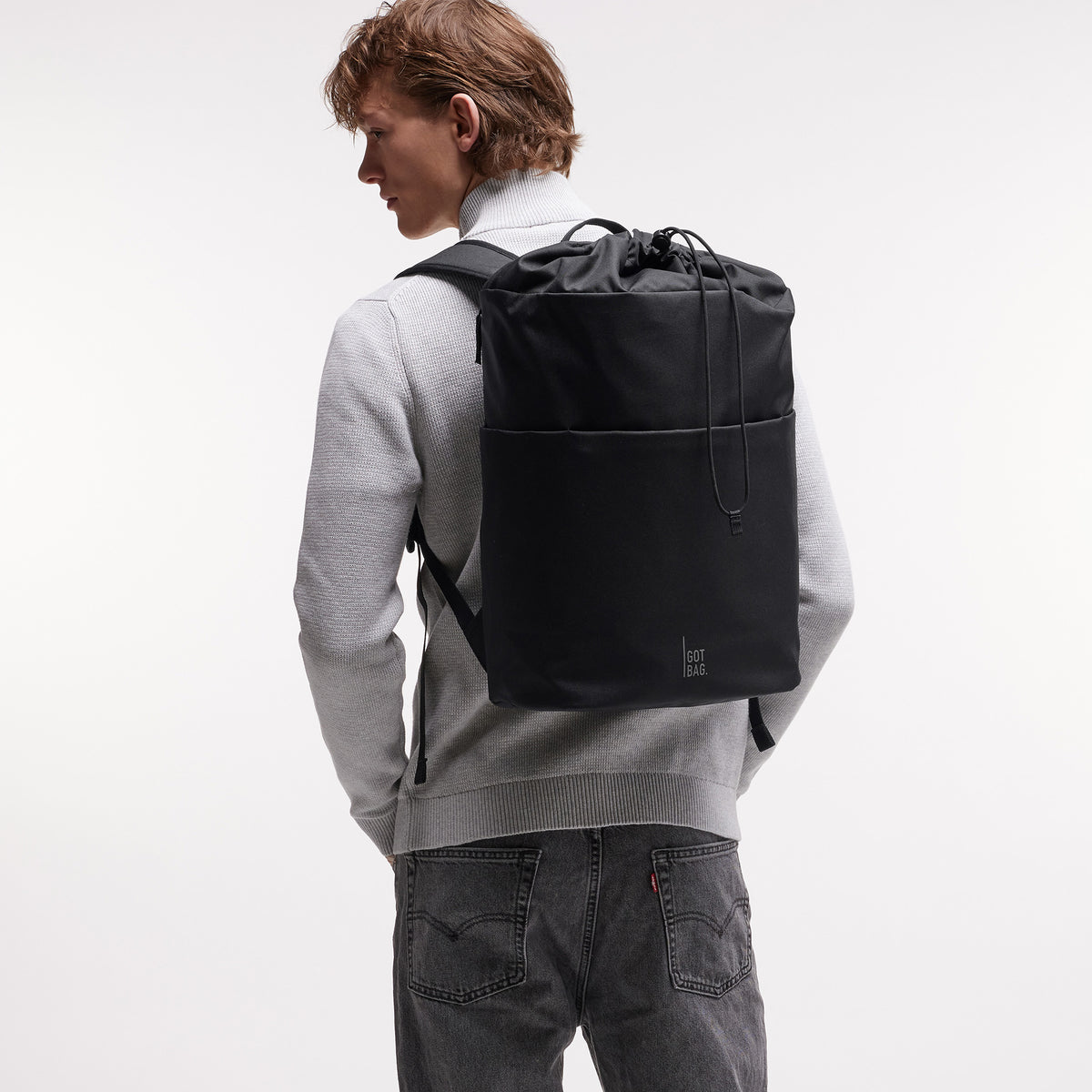 BARREL PACK Rucksack in black (Schwarz) von einem Mann auf dem Rücken getragen.