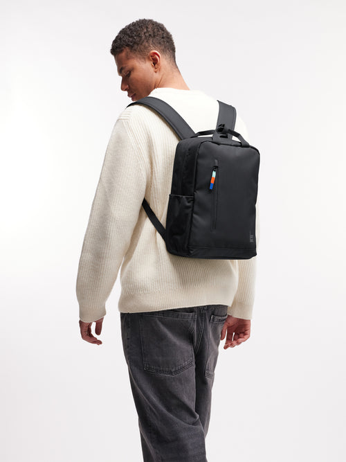 DAYPACK 2.0 Rucksack in black (Schwarz) von einem Mann als Rucksack auf dem Rücken getragen.