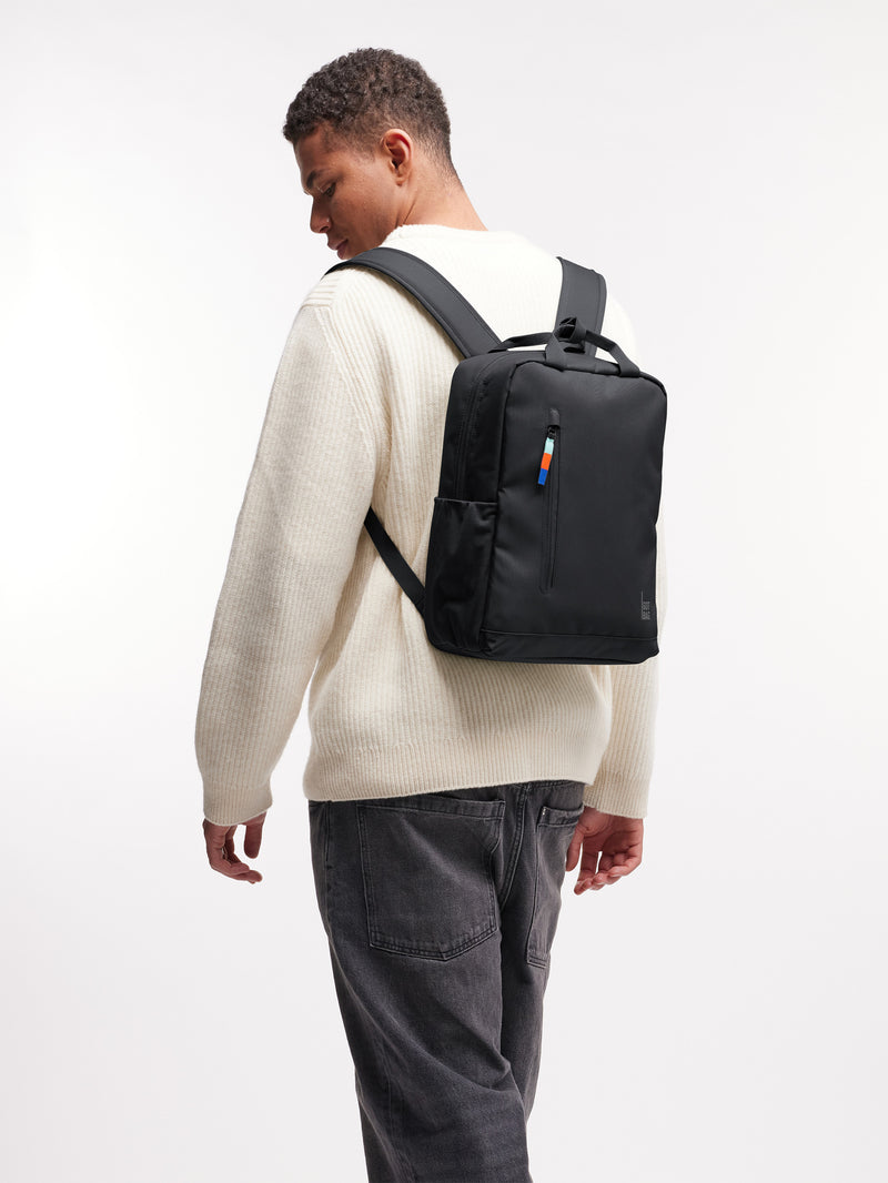 DAYPACK 2.0 Rucksack in black (Schwarz) von einem Mann als Rucksack auf dem Rücken getragen.