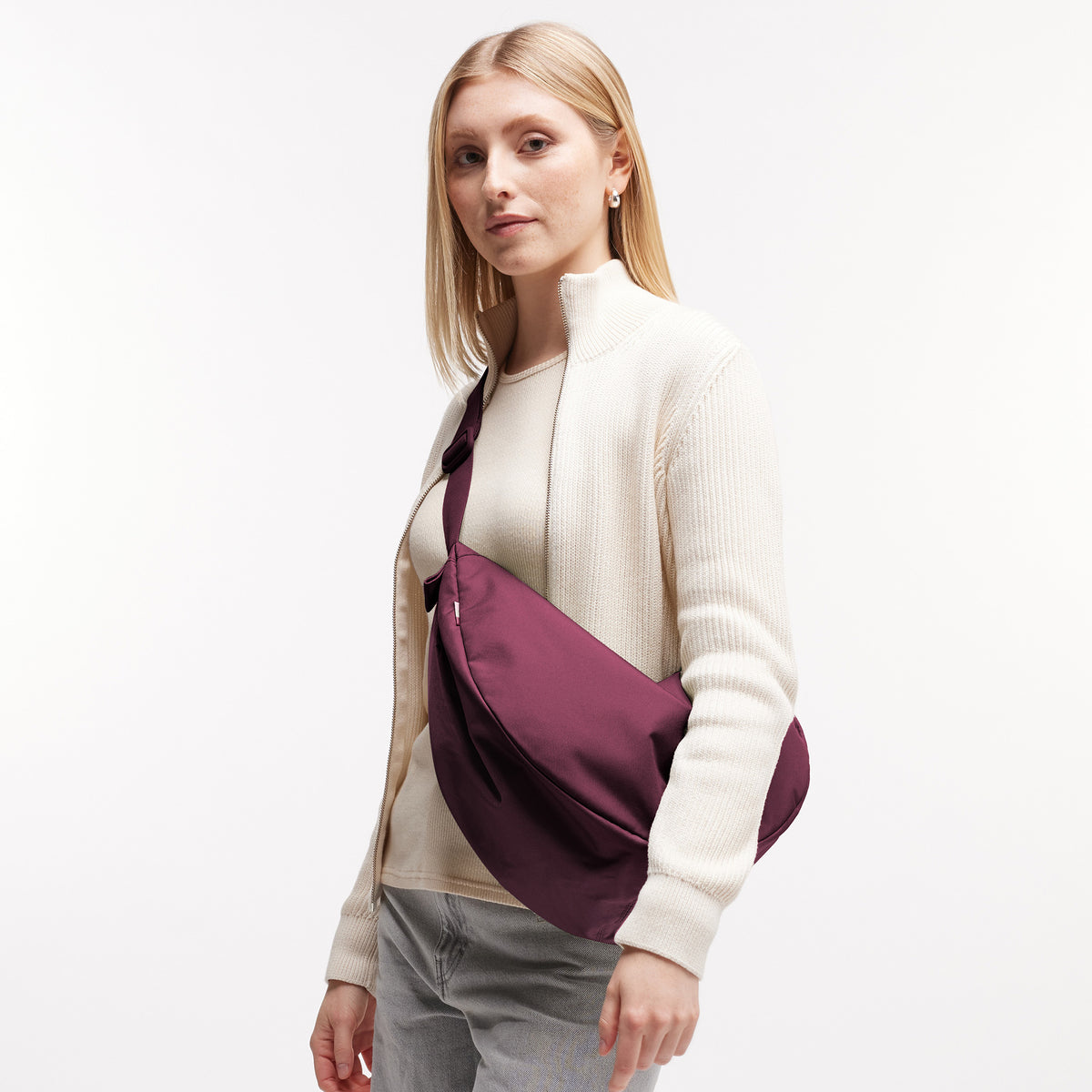 MOON BAG LARGE Tasche in kraken (Weinrot) von einer Frau crossbody getragen.
