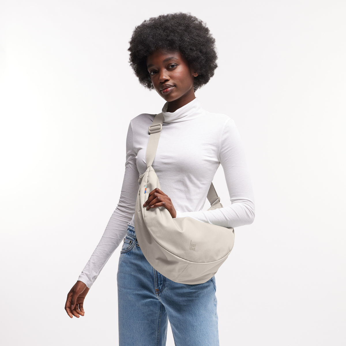 MOON BAG LARGE Tasche in soft shell (warmes Cremeweiß) von einer Frau crossbody getragen.