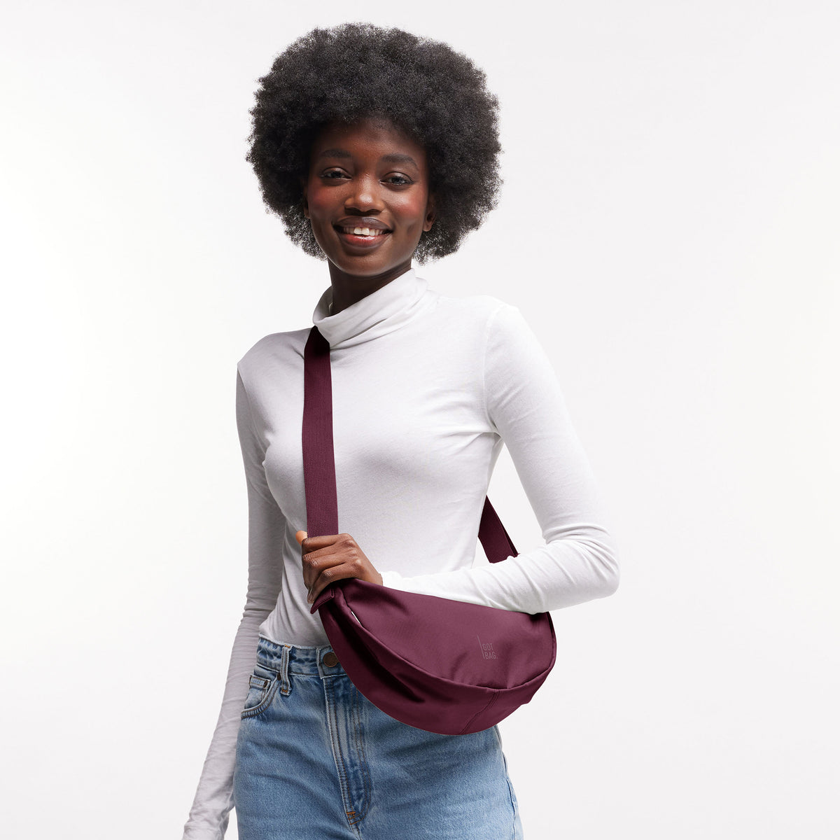 MOON BAG SMALL Tasche in kraken (Weinrot) von einer Frau crossbody getragen.