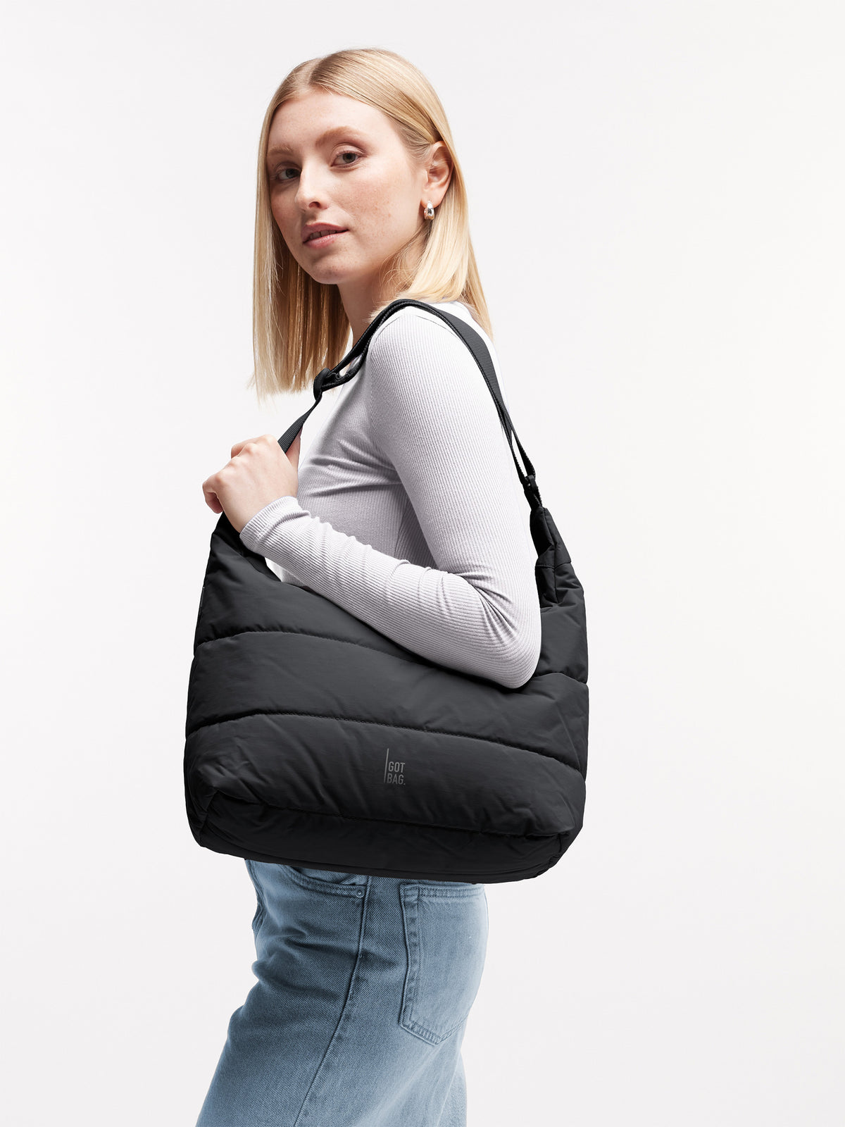 PUFFER SQUARE BAG Tasche in scallop (helles Beige) von einer Frau über der Schulter getragen.