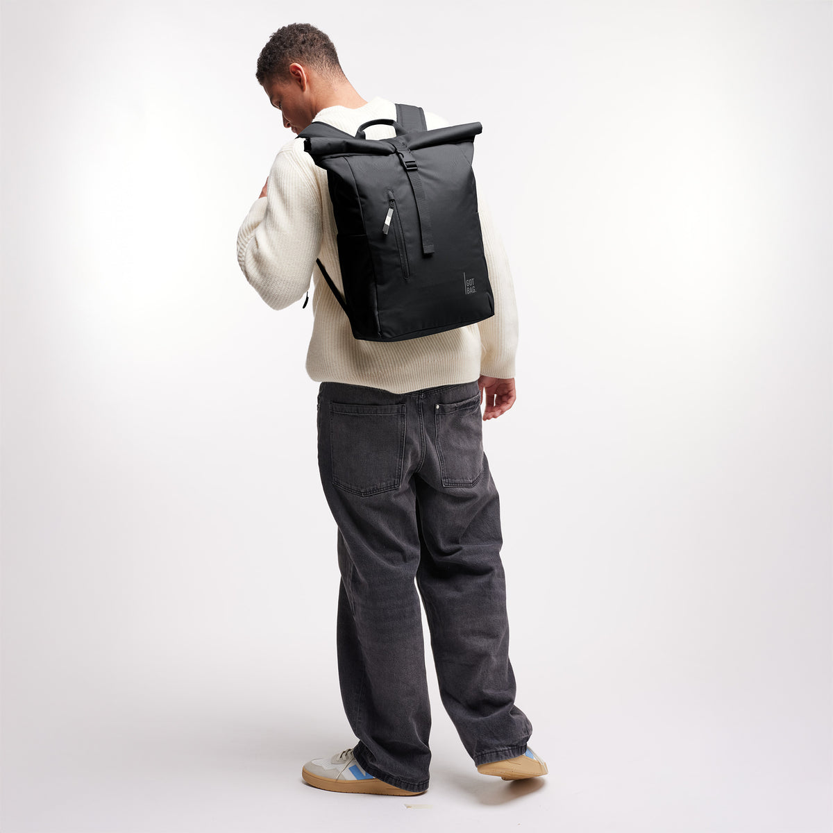 ROLLTOP EASY Rucksack in black (Schwarz) von einem Mann als Rucksack auf dem Rücken getragen.