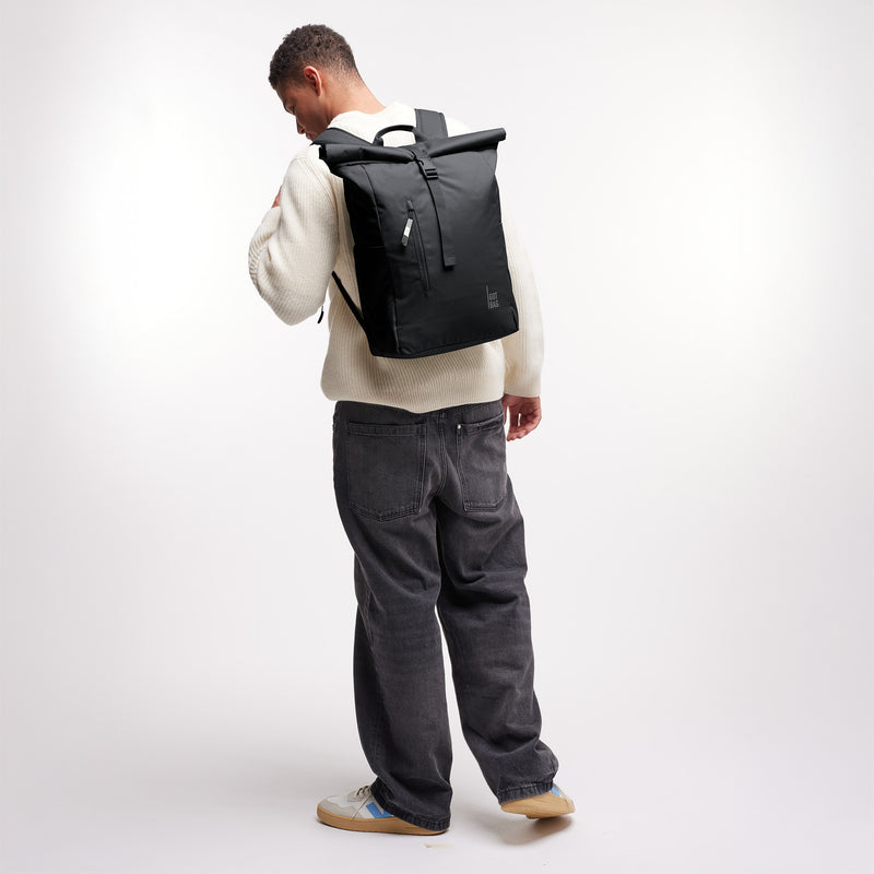 ROLLTOP EASY Rucksack in black (Schwarz) von einem Mann als Rucksack auf dem Rücken getragen.