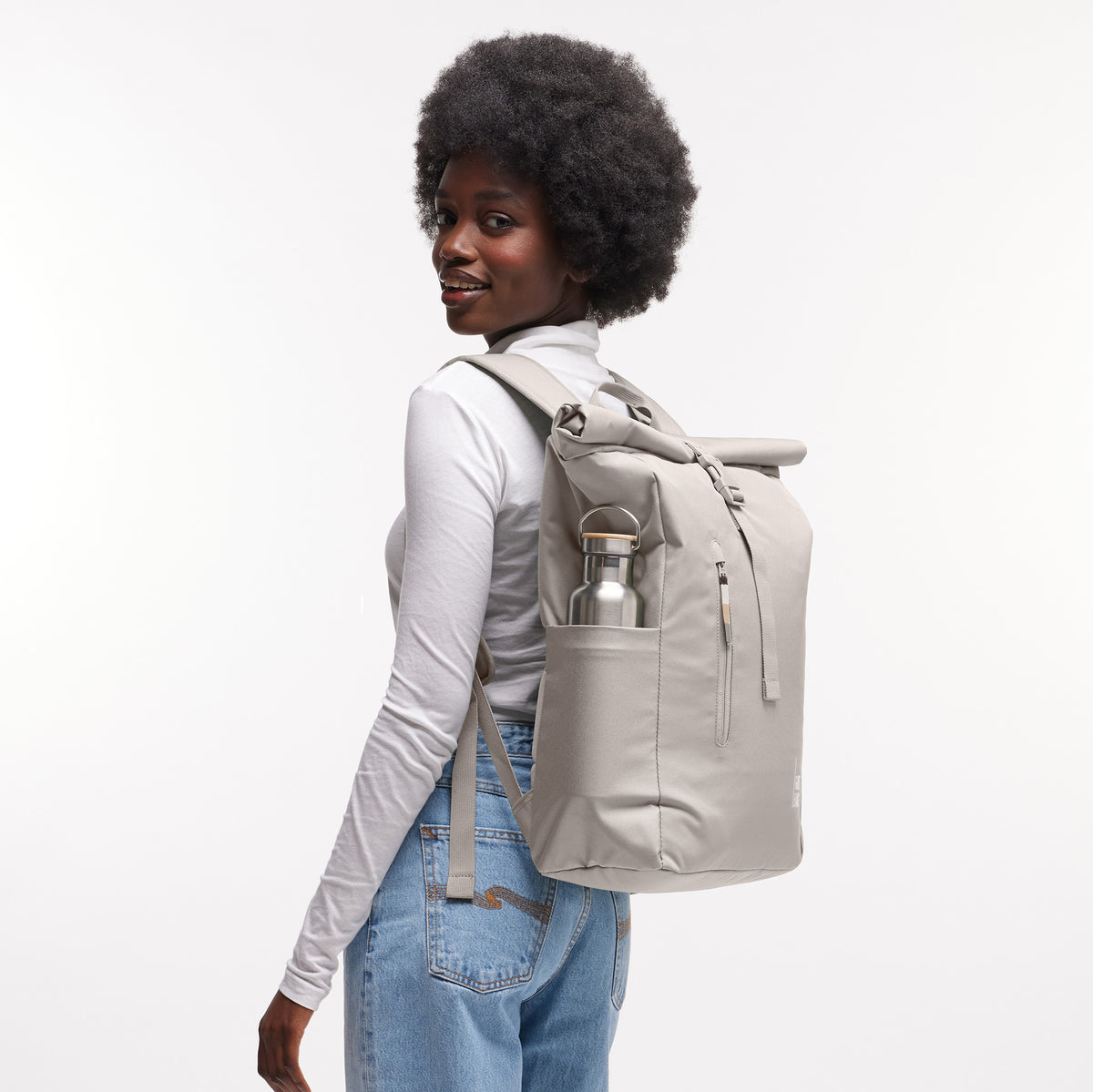 ROLLTOP EASY Rucksack in bass (Salbeigrün) von einer Frau auf dem Rücken getragen.